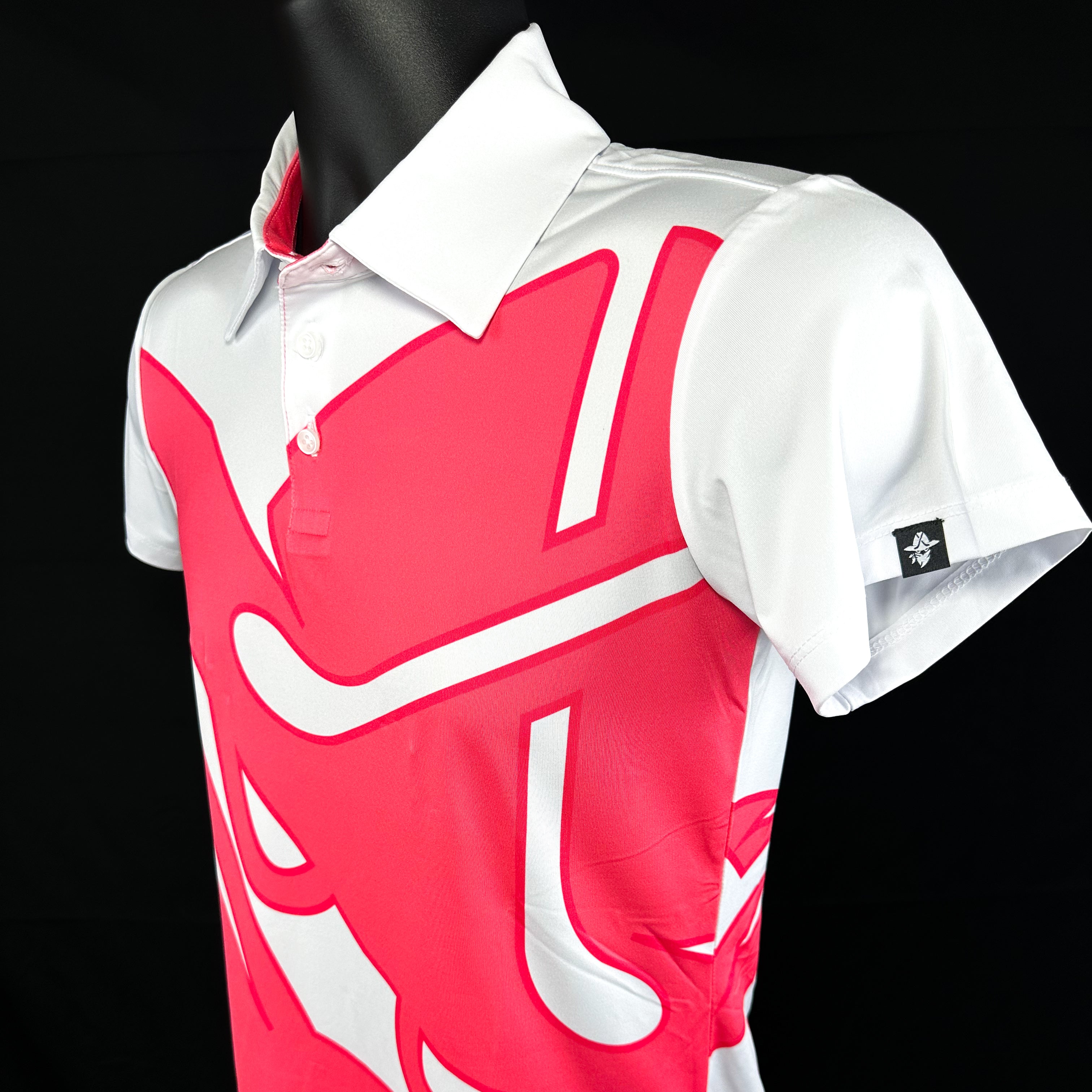 Full side view of Bandita Blossom Girls Junior Golf Polo in bold pink and white graphic design, laid flat to showcase the overall design, moisture-wicking fabric, SPF 50 protection, wrinkle-resistance, and 4-way stretch. Ideal junior golf clothing for girls aged 8-14. Golf Bandit Junior Golf Polos are the best quality in US Kids Golf apparel.