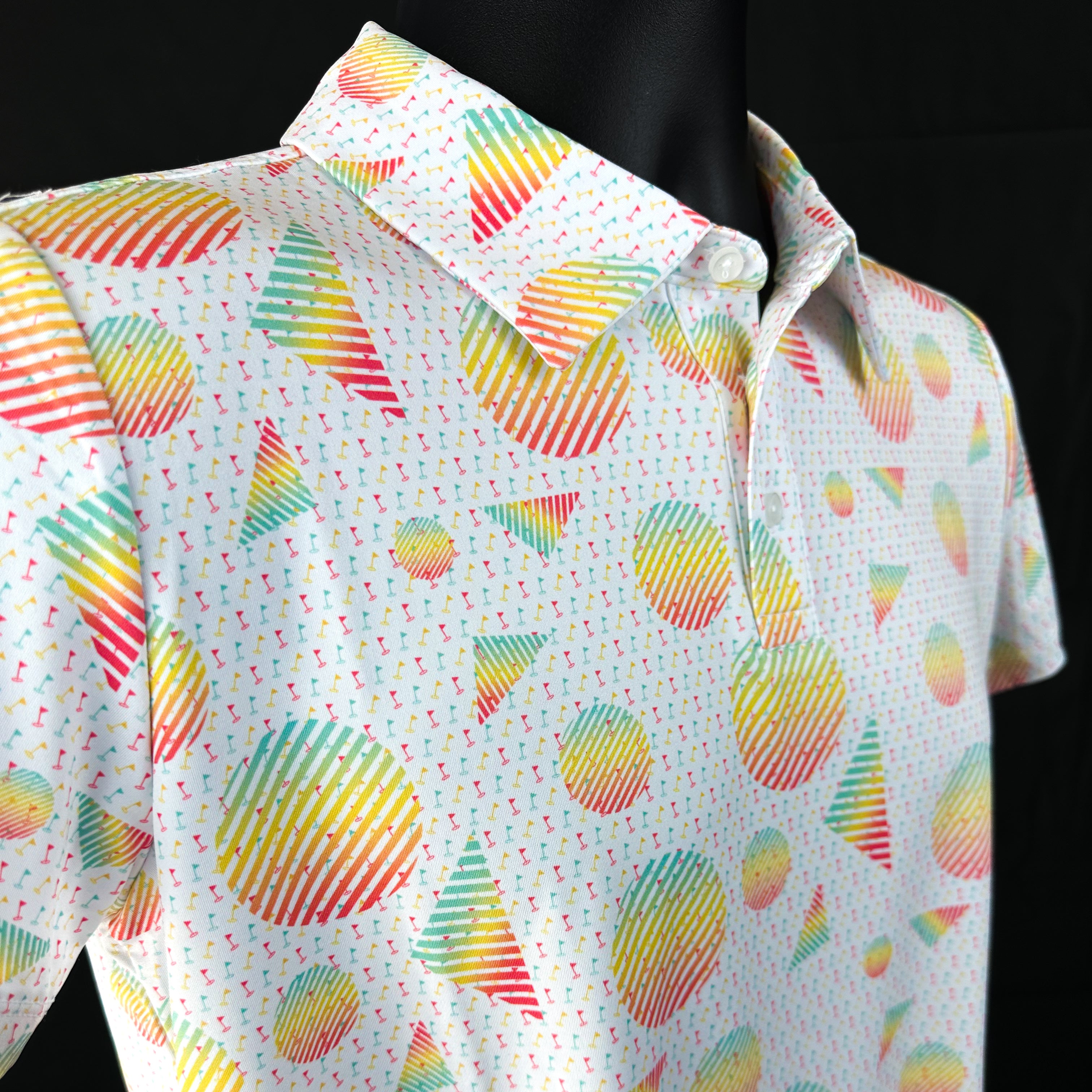 Close-up of Sharpshooter Boys Junior Golf Polo in a vibrant geometric design with mini golf flags, showcasing moisture-wicking fabric, SPF 50 protection, wrinkle-resistance, and 4-way stretch. Perfect junior golf clothing for boys aged 8-14. Golf Bandit Junior Golf Polos are the best quality in US Kids Golf apparel.